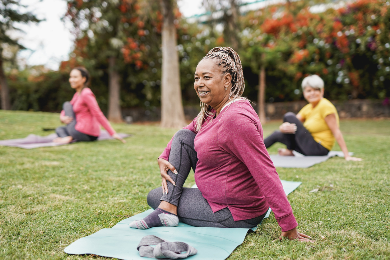 Multiracial women doing yoga exercise with social distance for coronavirus outbreak at park outdoor - Healthy lifestyle and sport concept